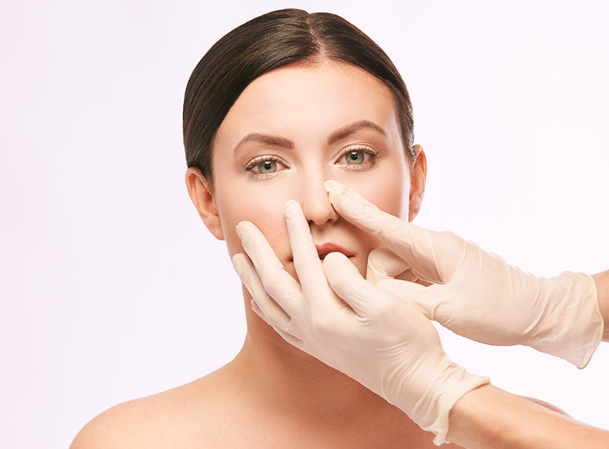 Doctor-touching-female-patient's-nose-before-septoplasty