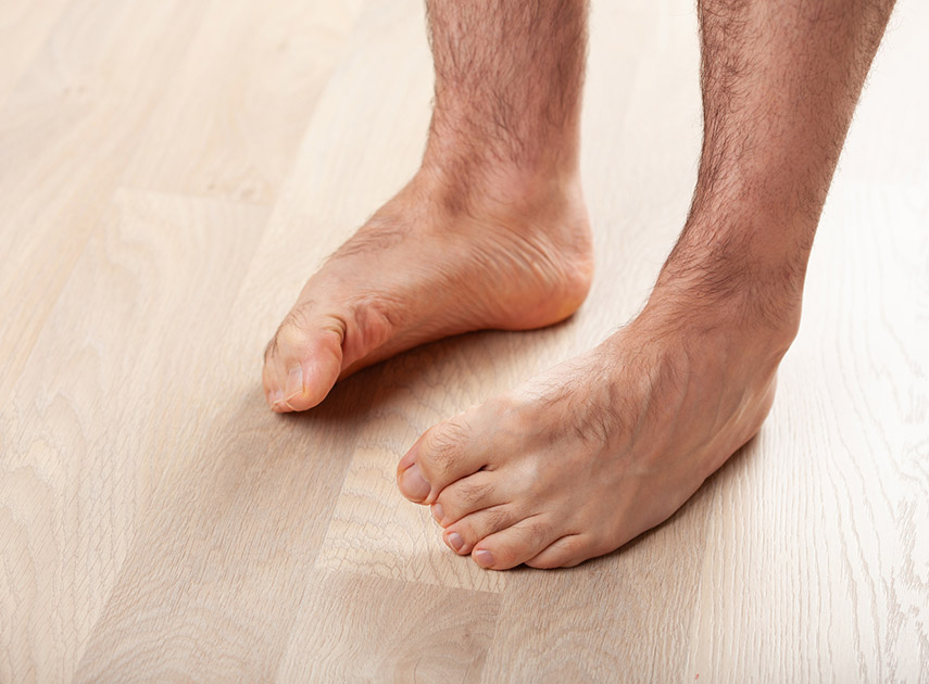 Man-standing-on-wooden-floor-with-flat-feet