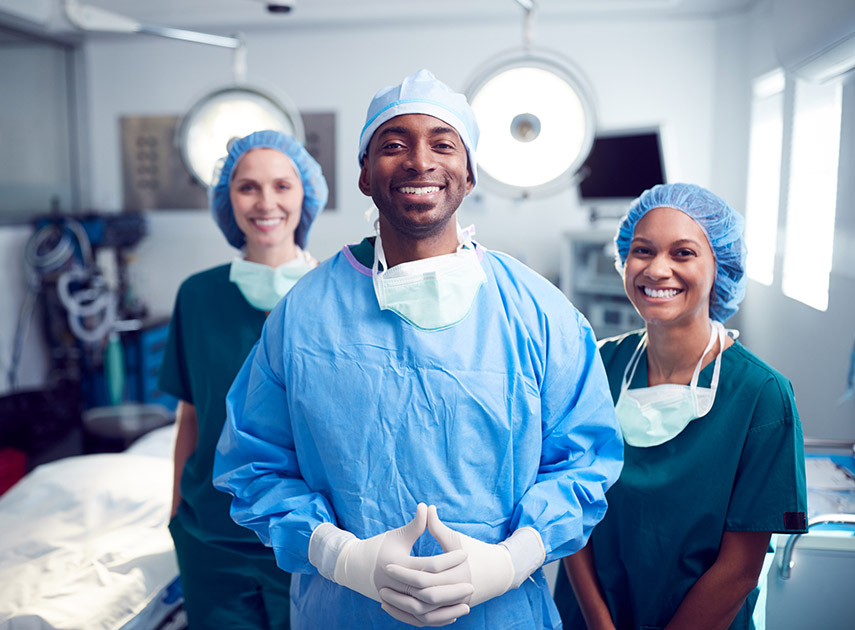 Smiling-surgical-team-standing-in-the-operating-room